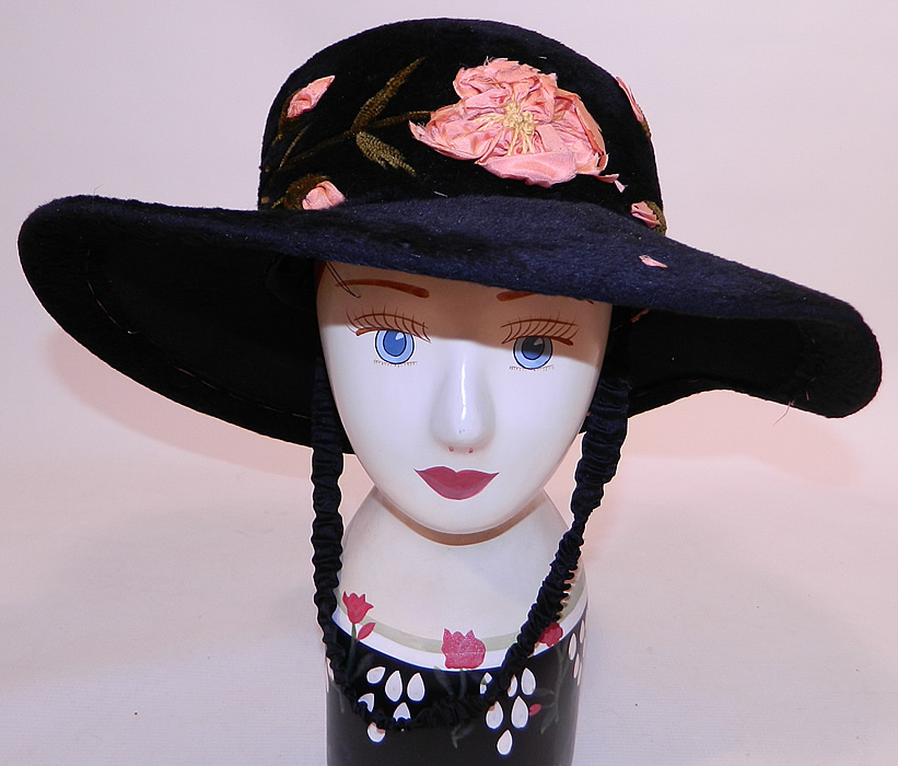 Edwardian Belle Epoque Black Plush Velvet Pink Silk Rosette Embroidered Wide Brim Hat
This Edwardian era Belle Epoque black plush velvet pink silk rosette embroidered wide brim hat dates from 1910.
