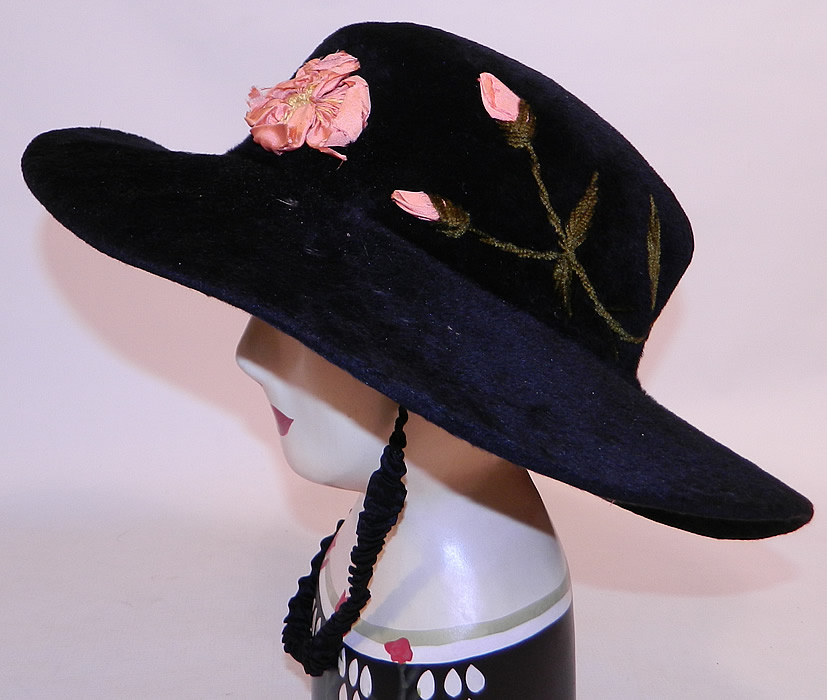 Edwardian Belle Epoque Black Plush Velvet Pink Silk Rosette Embroidered Wide Brim Hat
It is made of a black plush velvet felted fur nap, with pink silk ribbon work rosette flowers and green chenille embroidered leaf sprigs going around the crown. 