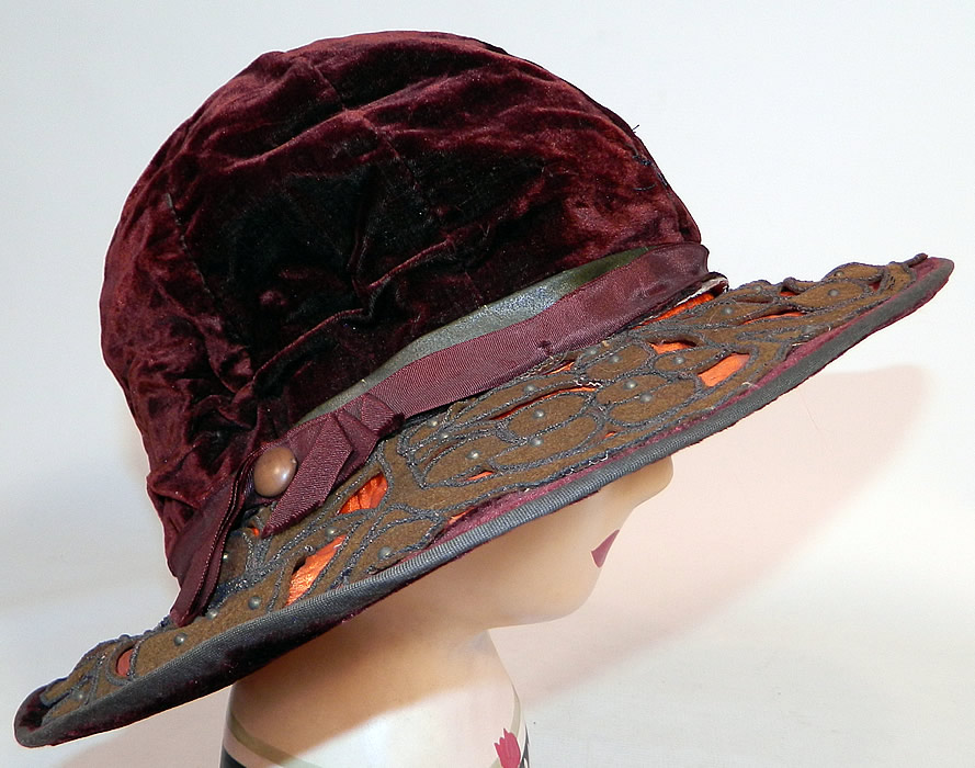 Vintage Burgundy Velvet Orange Silk Brown Cutwork Beaded Trim Wide Brim Cloche Hat
This fabulous flapper cloche style hat has a form fitting style with an uneven asymmetrical oval shape wide brim, which is wider along the sides and front. 