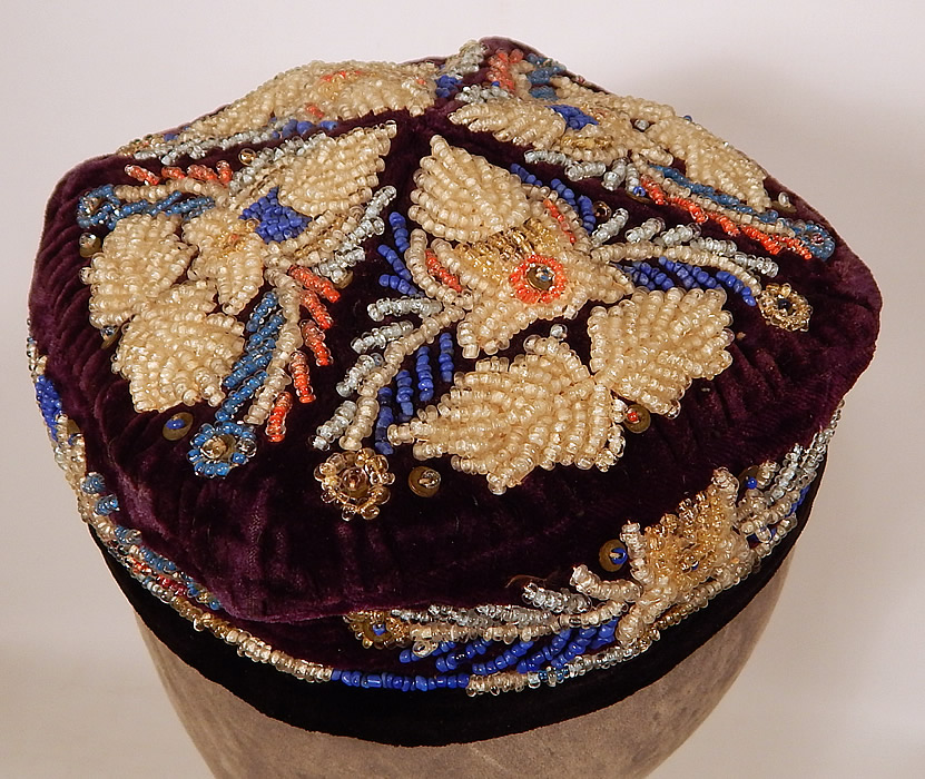Antique Uzbek Beaded Velvet Victorian Smoking Cap Duppi Hat Tubeteika
This beautiful beaded duppi folk hat has a small pill box skull cap style, with a squared shape top, black strap attached underneath for securing under the chin and is fully lined inside in a colorful red floral print cotton fabric. 