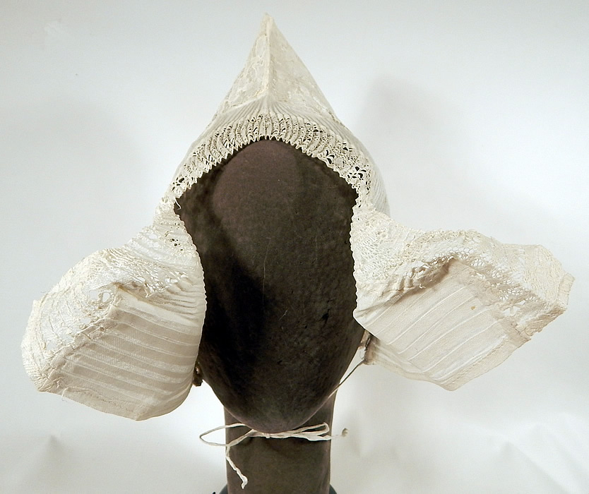 Vintage Antique Womens White Lace Dutch Folk Costume Bonnet Cap Hat
This vintage antique womens white lace Dutch folk costume bonnet cap hat dates from the late 19th century. It is made of a sheer white stiffened pleated cotton muslin and floral lace pattern fabric.
