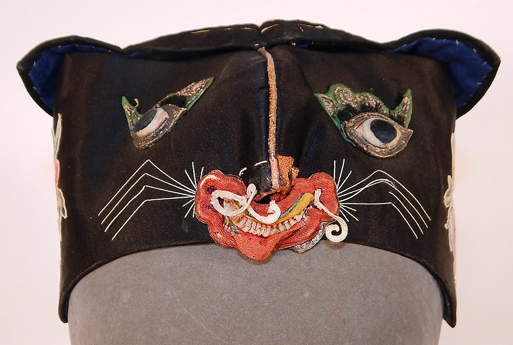 Antique Chinese Child Infant Silk Embroidered Applique Tiger Cat Wind Hat
This antique Chinese child infant silk embroidered appliqu&eacute; tiger cat wind hat dates from the 1920s. It is hand stitched, made of black silk with colorful raised padded satin stitch embroidery work and an appliqu&eacute;d tigers face on the front.