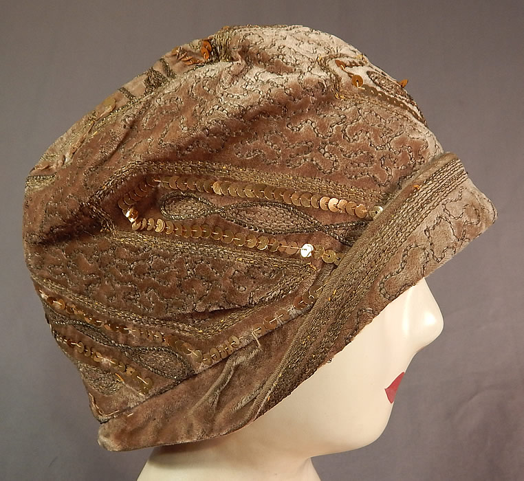 Vintage Art Deco Gold Lam&eacute; Embroidery Sequin Beaded Flapper Cloche Hat
The hat is made of a beige taupe color velvet fabric, with gold metallic lam&eacute; chain stitching embroidery work and gold metallic sequin beading all done in decorative geometric zigzag designs. 
