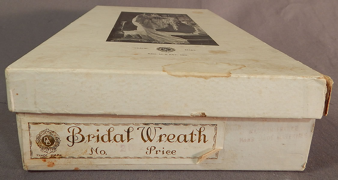 Vintage French Flapper Wax Flower Bridal Wreath Wedding Headband Headpiece & Box
The box measures 11 1/2 by 6 1/2 inches and is in good as-is condition, with some faint water spot stains and wear.