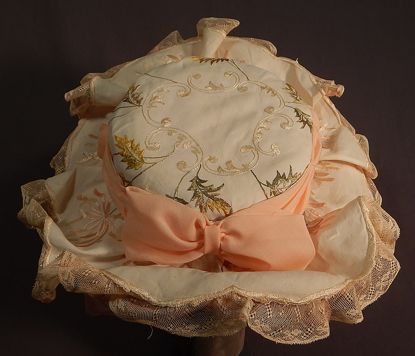Victorian Style Ruth Stockley Society Silk Embroidery Floral Peach Bonnet Hat
There is cream lace trim ruffle edging the brim, a peach ribbon hatband bow and pastel silk flower, bow trim on the back. This beautiful belle epoque bonnet style hat has an upturned wide brim with ruched pleated gathered peach fabric underneath, a tall round crown which is fully lined and would have sat atop a large full Gibson Girl style updo hairdo secured with long hat pins. 