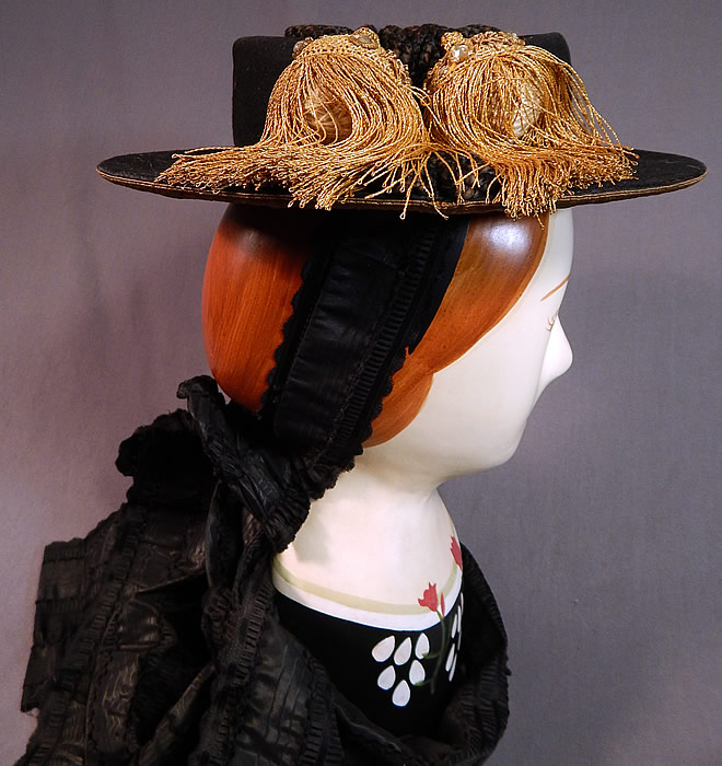 Antique Gold Bullion Embroidered Tracht Bavarian German Austrian Folk Costume Hat
There are gold tassels with rhinestone accents, black silk braided rope trim on the top and black silk moire ribbon attached with hook closures underneath the back of the head with a large bow trim and cascading ribbon streamers draping down the back. 