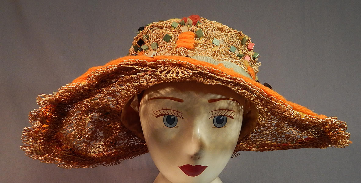 Vintage Woven Natural Straw Colorful Wood Beaded Embroidered Yarn Wide Brim Cloche Hat
The hat is made of a decorative sheer lattice work woven natural straw covered with colorful painted wooden square beads and brown, orange, yellow yarn embroidered in Art Deco geometric designs.