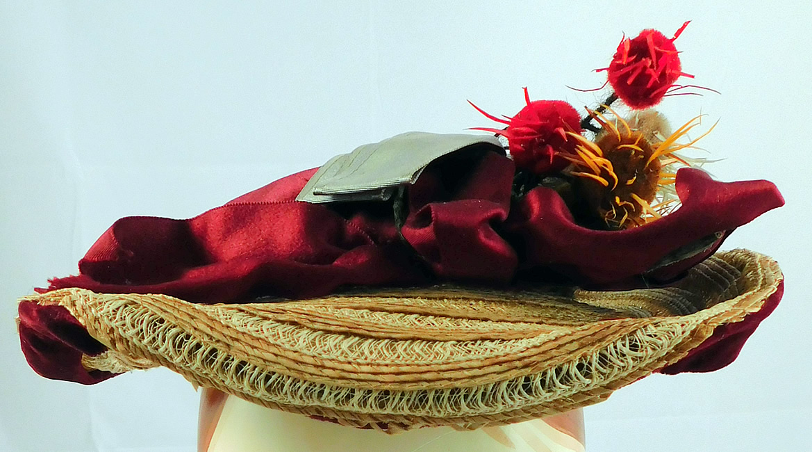 Victorian Womens Natural Straw Pork Pie Wide Brim Bonnet Hat Ribbon Thistle Trim
This charming ladies travel hat has a pork pie bonnet style with a low flat round shape, brim slightly upturned on the back with blue bow trim underneath and burgundy velvet edging, an attached chin strap and is unlined.