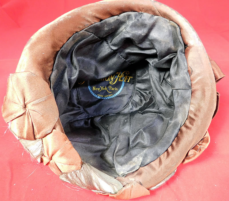 Vintage Fashion Hat Art Deco Brown Silk Silver Lame Rosette Flapper Cloche
It is in good as-is condition with some fraying along the silver lame rosette trim and a few small frayed snags pulls on the brown silk fabric crown (see close-ups).