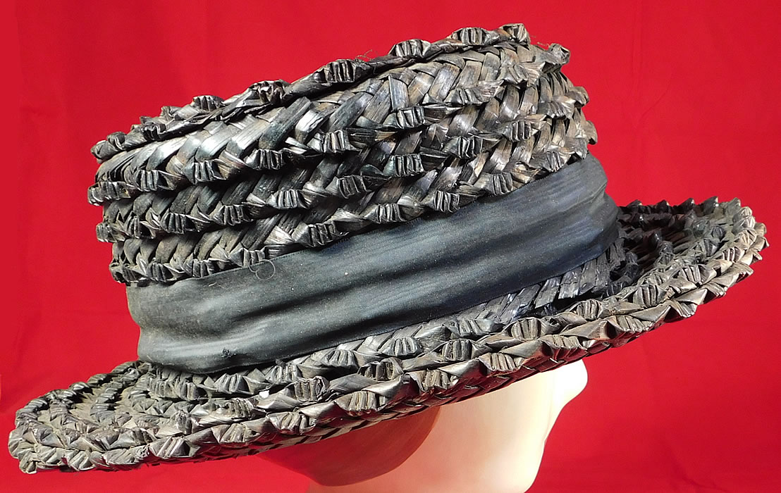 Edwardian Womens National Cloak Suit Co. NY Black Straw Boater Hat
It is made of a black woven straw, with a black silk moire ribbon hatband. This beautiful boater style womens summer hat has a stiff round low flat crown and brim.