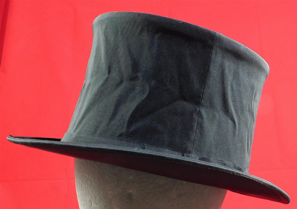 Vintage Finchley Establishment Fifth Ave NY Men's Black Silk Collapsible Opera Top Hat
It is made of a black silk grosgrain ribbed textured fabric, with matching hat band ribbon side bow trim. 