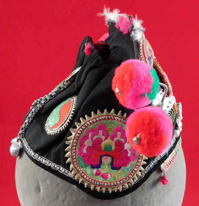 Antique Chinese Bai Miao Minority Childrens Festival Embroidered Tiger Wind Hat
The tigers ferocious powers make it an especially popular protective image and would have been used to frighten off evil spirits. This charming child's wind hat has yin and yang symbols, peony flowers, pheasant bird embroidered roundels medallion appliques on the sides and back with silver bells hanging down on chains, an open top crown and is fully lined with a colorful floral print cotton fabric inside. It is in excellent condition. 