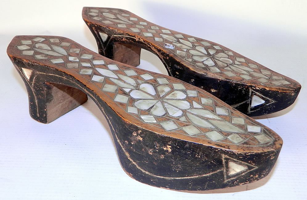 Antique Middle Eastern Mother of Pearl Inlaid Hand Carved Wooden Shoes. This pair of antique Middle Eastern mother of pearl inlaid hand carved wooden shoes date from the 1920s. They are made of hand carved wood painted black, inlaid in a mosaic design with mother of pearl.