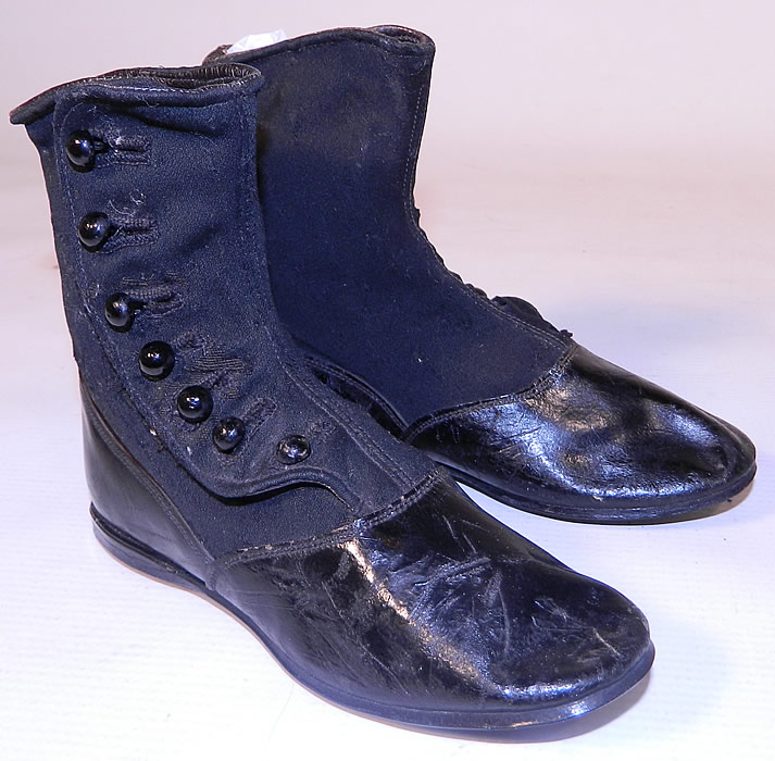 Victorian Black Wool Leather High Button Button Baby Boots Childs Shoes. They are made of a two tone black wool fabric top and black patent leather bottom shoe, with 7 black buttons down the side for closure. 