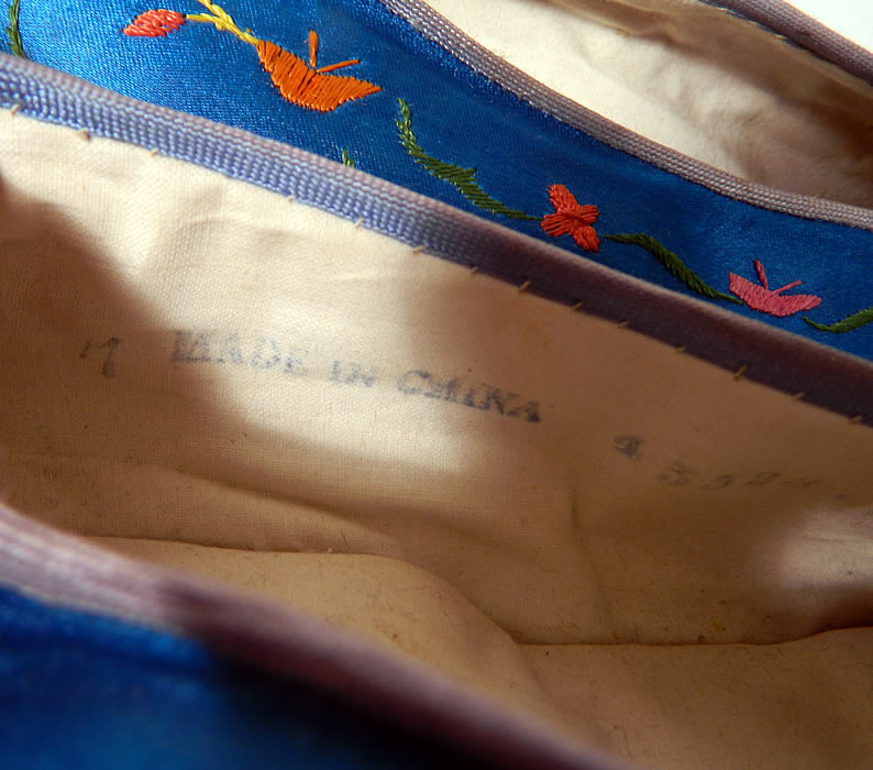Antique Chinese Royal Blue Silk Embroidered Floral Slipper Shoes. These slipper style slip-on shoes have hard leather bottom soles, embroidered blue silk covered heels and are fully lined in linen, with a "Made in China" size 7 ink mark stamped inside. 