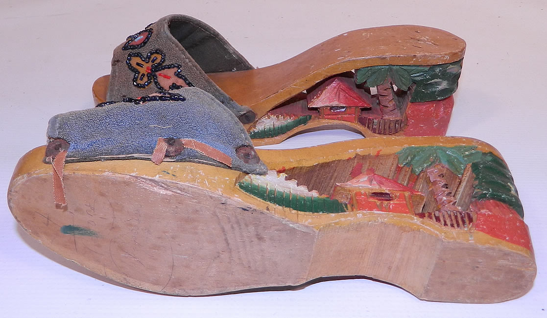 Vintage Philippines Hand Painted Carved Wooden Wedge Mules Sandal Shoes. They are in good condition, with some wear, dings and nicks on the wood and the trim edging along the fabric vamp sides is frayed and loose. These would make a great display piece and are truly a wonderful piece of hand crafted wearable retro shoe art!