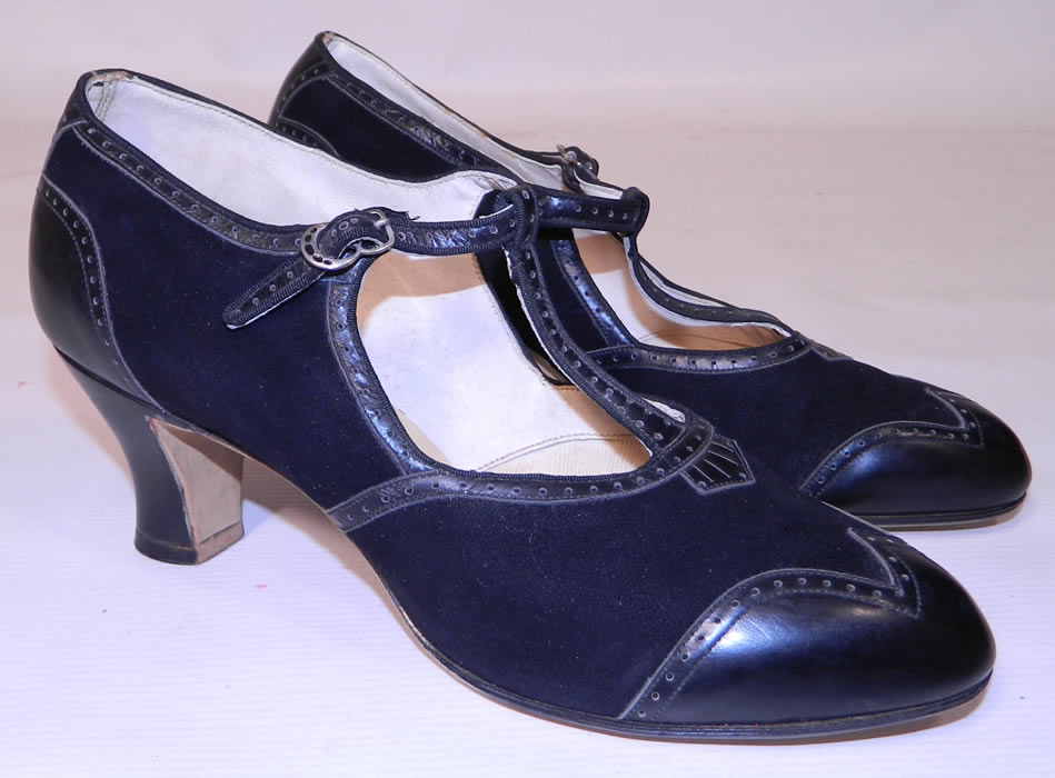 Unworn Vintage Active Maid  Brand Black Suede Leather  T-Strap Shoes. This pair of unworn vintage Active Maid brand black suede leather T-strap shoes date from the 1920s. They are made of black suede and black leather decorative punch work trim edging accents.