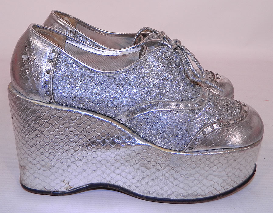 Vintage Di Orsini Silver Glitter Snakeskin Disco Platform Shoes. These sensational sexy silver disco shoes have a high platform lift, with silver shoestrings lace-ups. 