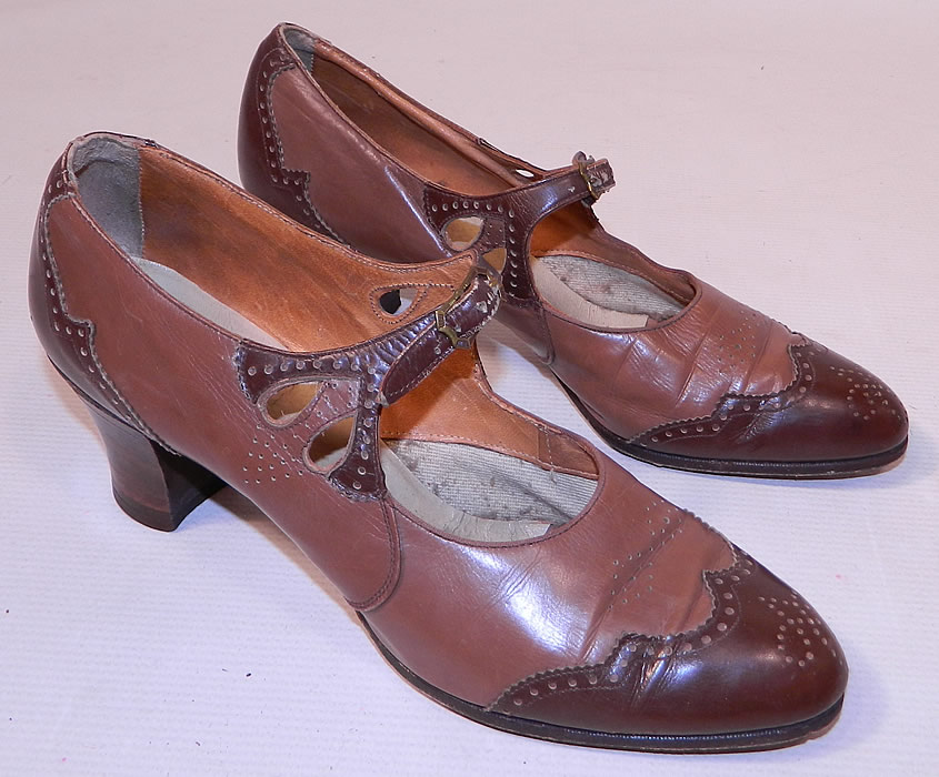 Vintage Two Tone Punchwork Brown Leather Buckle Strap Mary Jane Shoes. This pair of vintage two tone punchwork brown leather buckle strap Mary Jane shoes date from the 1920s. They are made of two tone brown color leather with decorative punchwork, scalloped trim edging details.