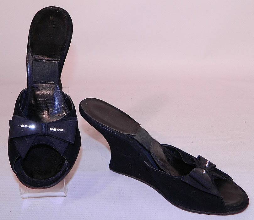 Vintage Black Suede Leather Rhinestone Bow Springolator Wedge Heel Mules Shoes. They are made of black suede leather, with black silk rhinestone studded bow trim on the front vamps insteps. 