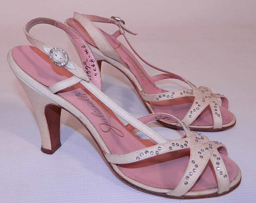 Vintage Julianelli White Linen Rhinestone Strap Sling Back Sandal Shoes. This pair of vintage Julianelli white linen rhinestone strap sling back sandal shoes date from the 1950s. They are made of an off white ivory cream color linen fabric, with tiny silver studded rhinestones trimming the instep front vamp straps.