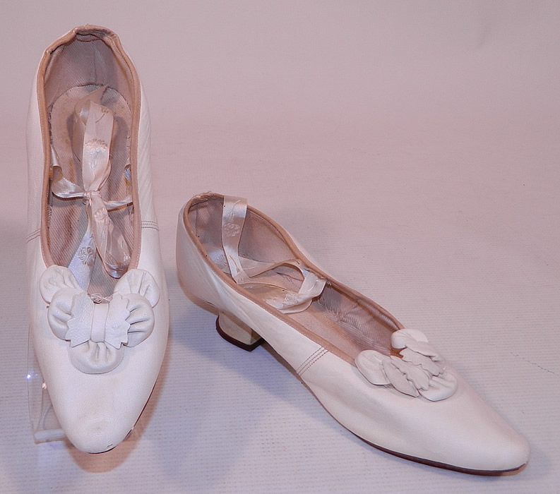 Victorian White Kid Leather Bow Trim Silk Ribbon Ties Wedding Shoes
This pair of antique Victorian era white kid leather bow trim silk ribbon ties wedding shoes date from the 1880s. These delicate wedding slippers were reserved for indoor wear, evening dress or special occasions and would make for a great display piece! They are truly a wonderful piece of antique Victoriana bridal wedding shoe art!