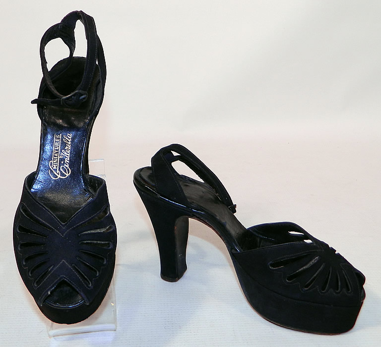 Vintage Miniatures by Cinderella Black Suede Leather Ankle Strap Platform Shoes
This pair of vintage Miniatures by Cinderella black suede leather ankle strap platform shoes date from the 1940s. They are made of a black suede leather, with a decorative eyelet cut out pattern design on the front instep vamps.