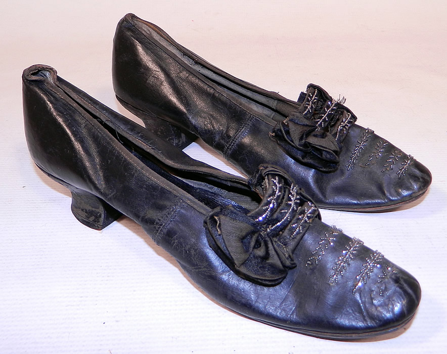 Victorian Black Leather Silk Bow Steel Cut Beaded Louis XV Heel Shoes
This pair of antique Victorian era black leather silk bow steel cut beaded Louis XV heel shoes date from 1870. They are made of black leather, with black silk bows, three straps across the instep front vamps and steel cut beaded trim. 