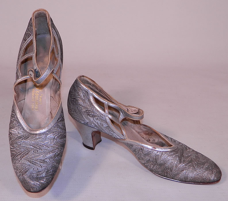 Vintage Silver Leather Lam&eacute; Lame Brocade Button Strap Mary Jane Flapper Shoes
This pair of vintage silver leather lam&eacute; brocade button strap Mary Jane flapper shoes date from the 1920s.  The shoes measure 10 1/2 inches long, 2 1/2 inches wide, with a 2 1/2 inch high heel and are approximately a size 7 or 8 narrow width. They have been gently worn and are in good condition, with only some slight faint tarnish discoloration. These are truly a wonderful quality made shoe and wearable Art Deco shoe art!