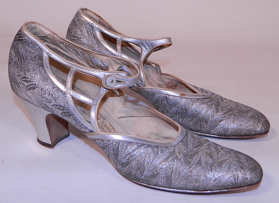 Vintage Silver Leather Lam&eacute; Lame Brocade Button Strap Mary Jane Flapper Shoes
They are made of a silver lam&eacute; damask weave brocade fabric, with a woven berry leaf pattern design and silver metallic leather trim edging. 
