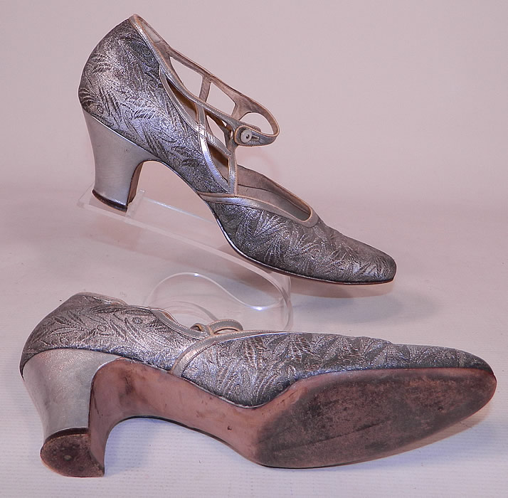 Vintage Silver Leather Lam&eacute; Lame Brocade Button Strap Mary Jane Flapper Shoes
These fancy flapper evening shoes have a Mary Jane style, with a mother of pearl button closure, cut out side straps across the instep vamps, rounded toes and silver leather covered cube heels. 