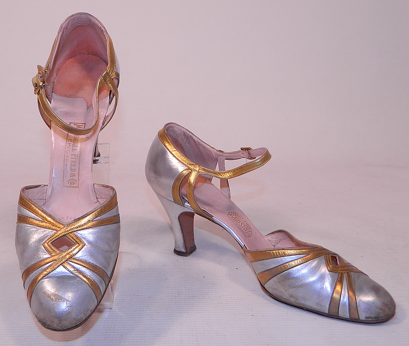 Vintage Marshal Field & Co Aristo Art Deco Silver Gold Leather Ankle Strap Evening Shoes
These elegant evening flapper dance shoes have decorative Art Deco designs, a key hole peek-a-boo opening on the front instep vamps, adjustable ankle straps with rhinestone gold buckle closures and silver leather covered modified boulevard high heels.
