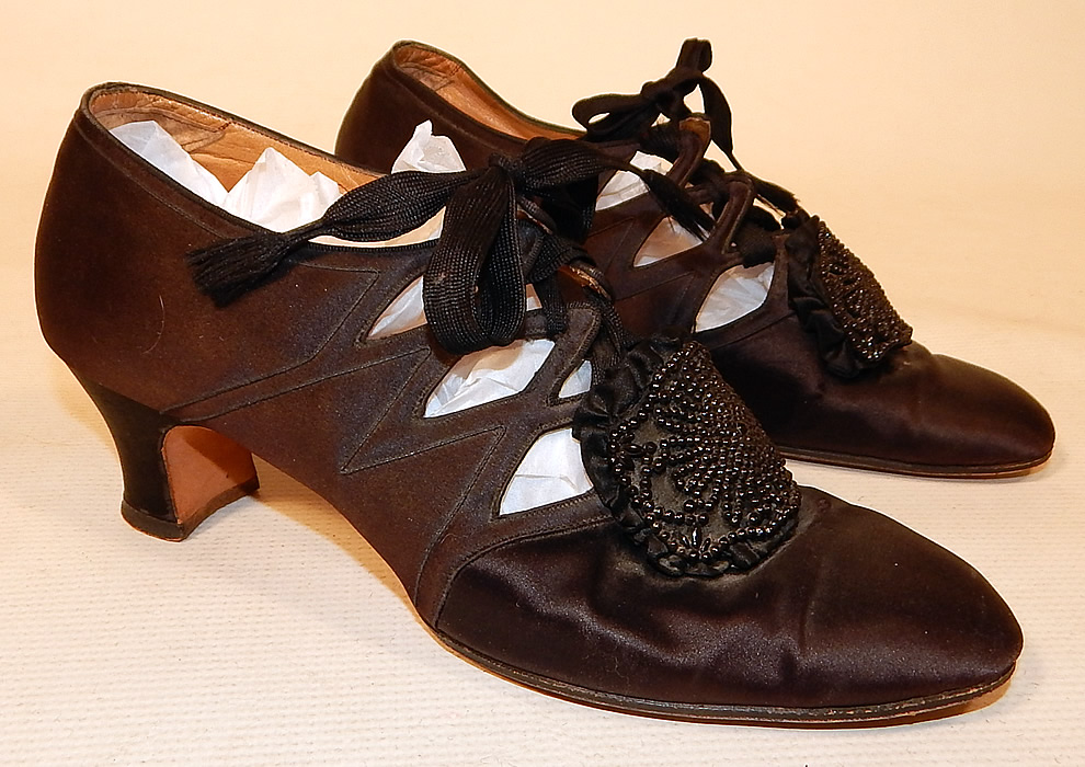Vintage Thayer McNeil Co Boston Black Silk Beaded Buckle Eyelet Flapper Shoes
They are made of a black silk satin fabric with black beaded buckle trim on the front instep vamps. 
