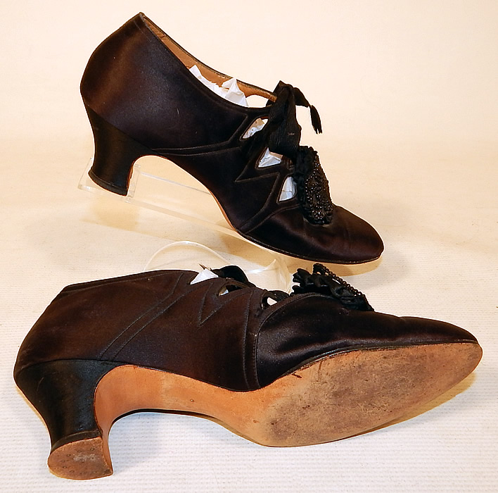 Vintage Thayer McNeil Co Boston Black Silk Beaded Buckle Eyelet Flapper Shoes
These fabulous flapper shoes have decorative eyelet cut out openings along the sides with lacing closures and silk covered cube heels. 