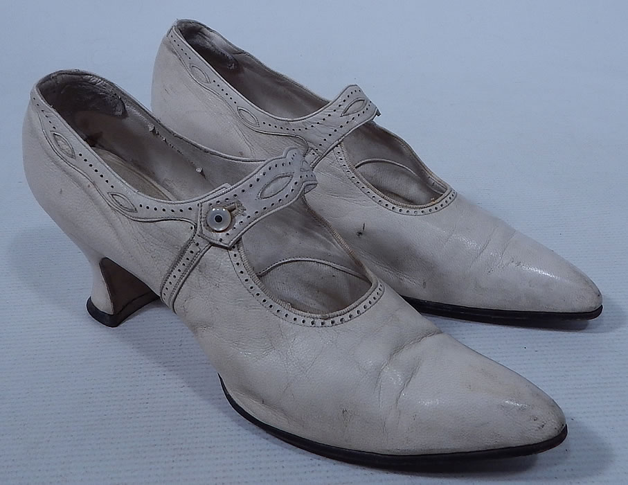 Edwardian Vintage H.H. Tuttle Co. White Leather Button Strap Mary Jane Shoes
This pair of Edwardian era vintage H.H. Tuttle Co. white leather button strap Mary Jane shoes date from 1910. They are made of a white leather with decorative punch work and eyelet trim.
