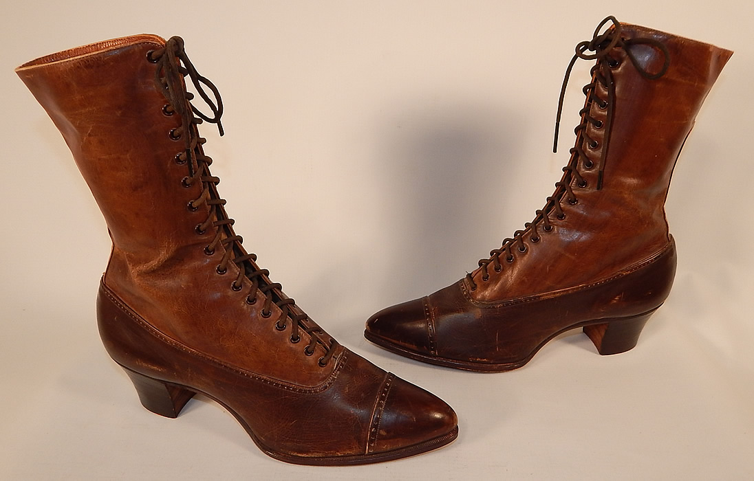 Unworn Victorian Brown Two Tone Leather High Top Lace-up Boots Shoes
This pair of unworn antique Victorian era brown two tone leather high top lace-up boots shoes dates from 1900. They are made of a supple brown two tone color leather, with decorative punch work designs on the toes and a darker brown color bottom shoe.