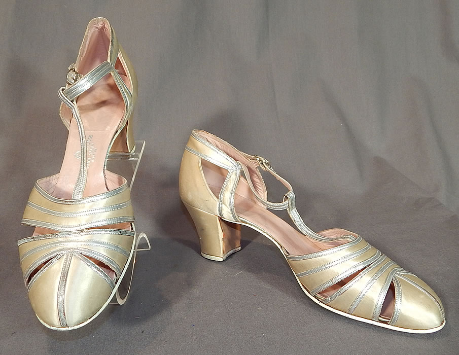 Vintage C. Crawford Hollidge Shoe Salon Cream Silk Satin Silver Leather T-Straps
These beautiful bridal wedding, evening shoes have a T-strap style, with an adjustable ankle strap buckle closure, peek-a-boo cutwork straps on the front toes and satin covered modified boulevard high heels.