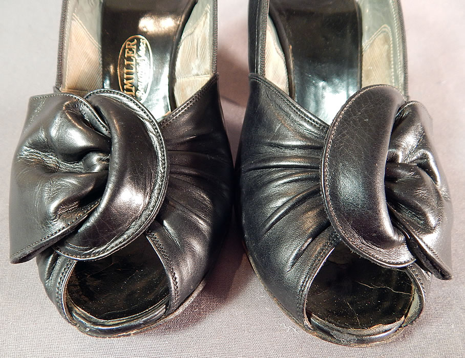 Vintage I. Miller Black Patent Leather Sling Back Peep Toe Pumps Pinup Shoes 
They are made of a black patent leather. These beautiful bombshell pinup pumps shoes have open peep toes, with knotted buckle trim on the instep front vamp, an adjustable side buckle strap, sling back style and patent leather covered modified boulevard heel.