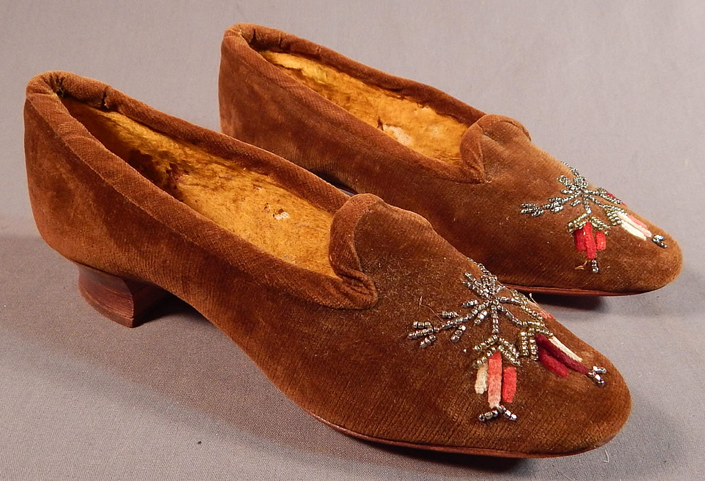 Victorian Brown Velvet Chenille Embroidered Steel Cut Beaded Slipper Shoes
This pair of antique Victorian era brown chenille embroidered steel cut beaded slipper shoes date from 1870. They are made of a brown velvet fabric, with red ombre chenille hand embroidery work and steel cut beading snowflake designs on the front toes.