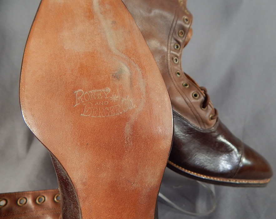 Unworn Edwardian Brown Two Tone Leather High Top Lace-up Boots & Shoe Box
This pair of unworn antique Edwardian era brown two tone leather high top lace-up boots and shoe box dates from 1910. They are made of a supple brown two tone color leather. These beautiful boots have pointed toes, the original brown shoe string laces for closure, stacked wooden cube heels and are stamped on the bottom leather soles "Roney and Berger Co.".