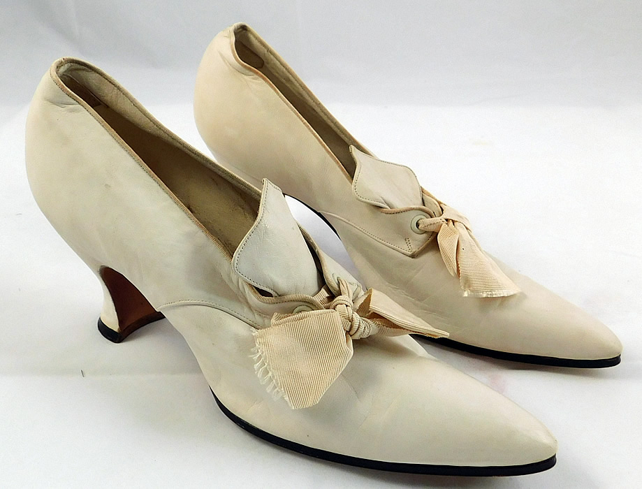 Edwardian Vintage La Valle & Lo Presti White Kid Leather Pointed Toe Shoes
These wonderful womens wedding shoes have a slip on slipper style have a decorative tongue top, cream silk grosgrain ribbon bow tie lacing closure, elongated pointed toes, kid leather covered French Louis XV heels, lined in leather
