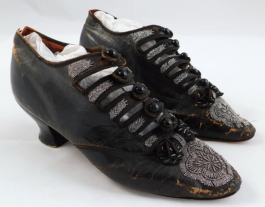 Victorian Antique Brown Leather Steel Cut Beaded 5 Button Strap Shoes
They are made of a dark brown leather with silver steel cut beading along the button straps, black silk bow trim on the instep vamps and beaded rosette flowers on the toes. 
