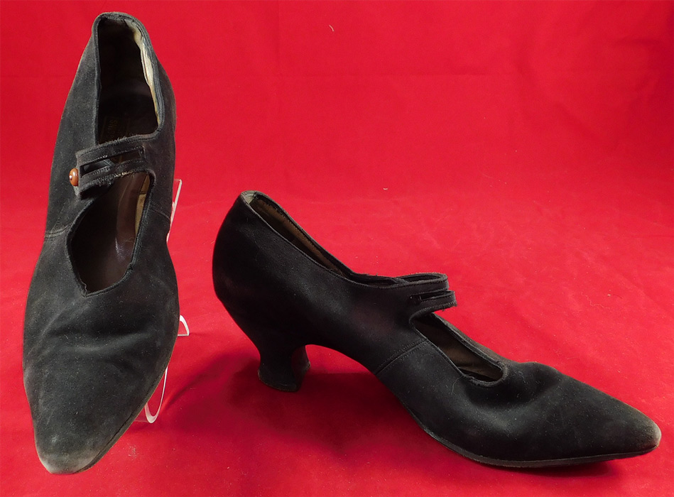 Vintage Fred T. Huggins Edwardian Black Suede Button Strap Mary Jane Shoes
These womens Mary Jane style shoes have a cutout strap with a brown button closure across the front instep vamps, pointed toes and black suede leather covered French Louis XV spool heels.