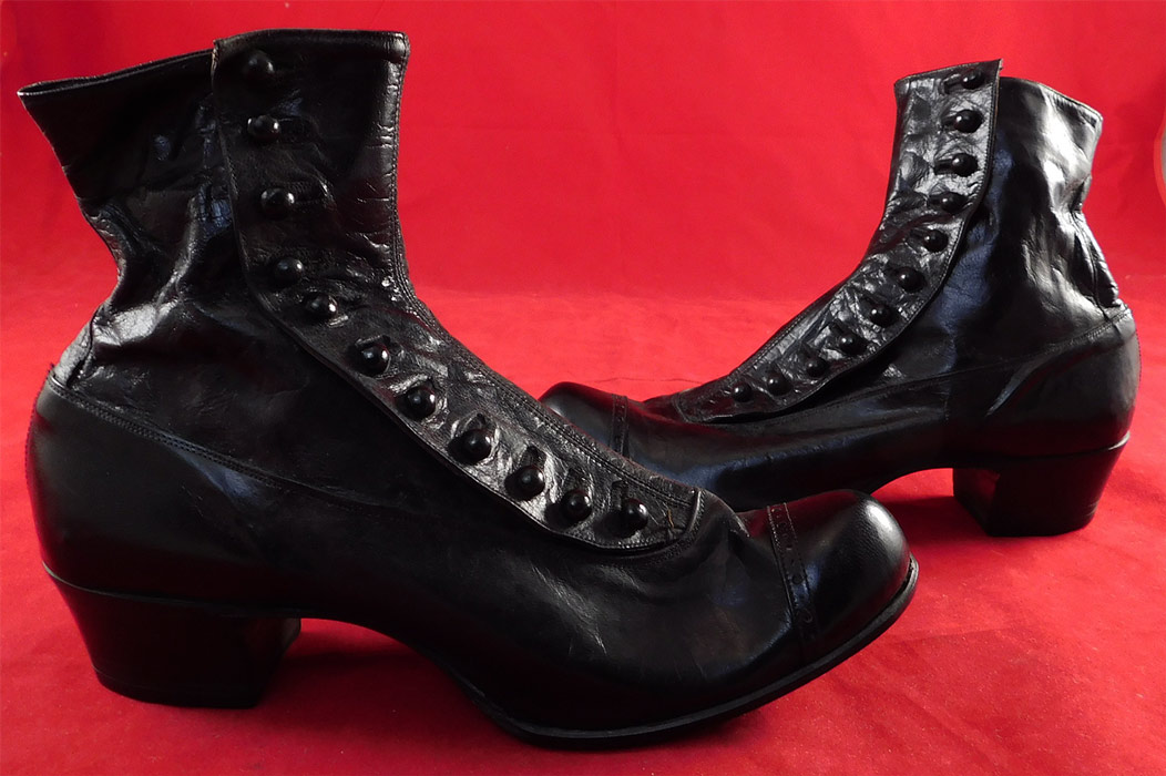 Victorian Unworn Womans Black Kid Leather High Top Button Boots
These beautiful boots have bulbous rounded toes with decorative punch work designs, 11 black shoe buttons along the side for closure and stacked black wooden cube heels. 