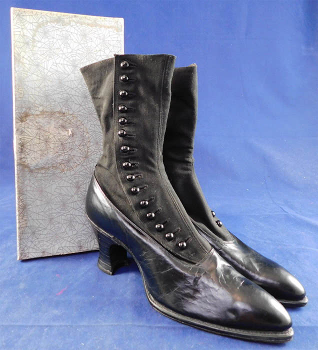 Unworn Edwardian Black Cloth Top Kid Leather Button Boots & Spiderweb Shoe Box
This pair of unworn antique Edwardian era black cloth top, kid leather button boots and spiderweb shoe box date from 1910. They are made of black wool cloth fabric upper boot and black kid leather lower shoe. 