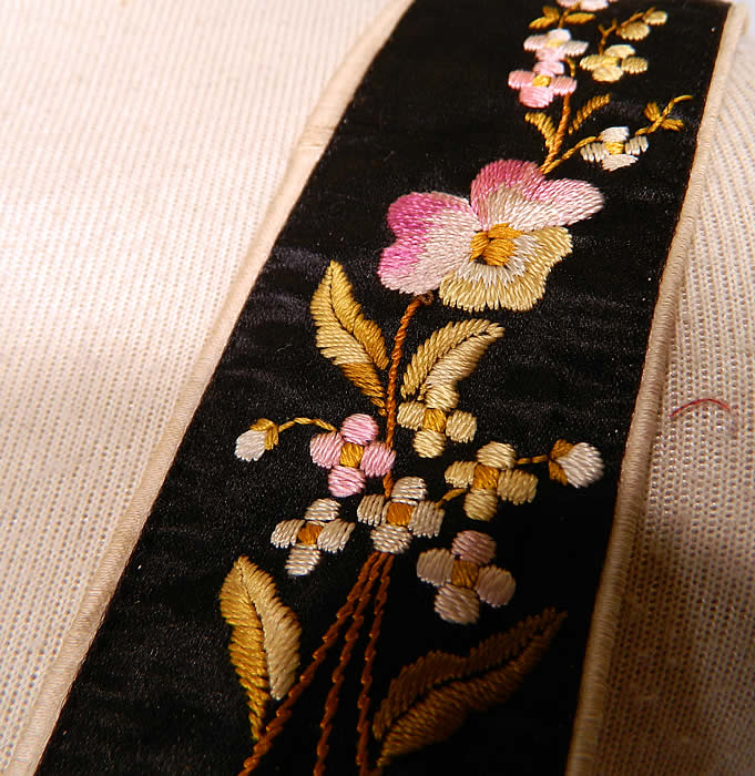 Victorian Pansy Forget Me Not Black Silk Embroidered Mourning Braces Suspenders. The suspenders are backed in an off white silk fabric, with black elastic straps and leather button loop attachments for attaching to the pants. The suspenders measure 33 inches long and are 2 inches wide.