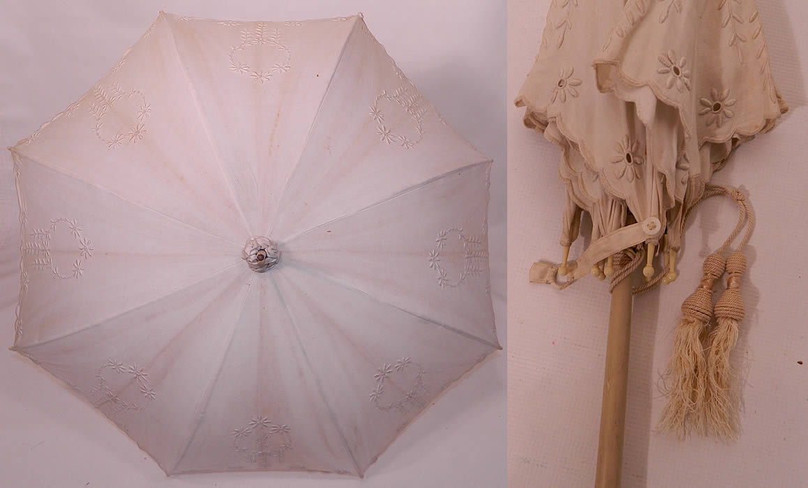 Edwardian Eyelet Embroidered White Linen Wood Handle Summer Parasol. There is a floral daisy design and monogrammed initials "FG" inside the front shield. This pretty parasol umbrella has a white washed painted wood handle, with metal frame inside, celluloid tips, original button strap for keeping closed, cream tassel trim pair and finial top with gathered scrunchie fabric trim.