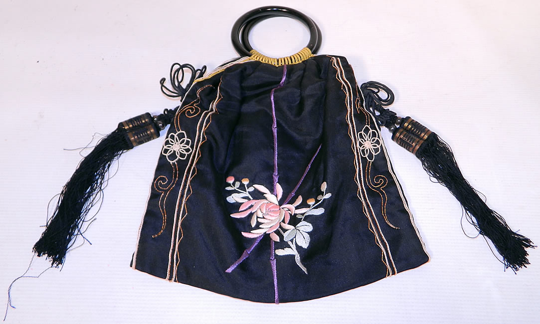 This pretty purse has been beautifully embroidered and created into a pouch bag style purse, with a two black glass circular loop ring handles on top for carrying.