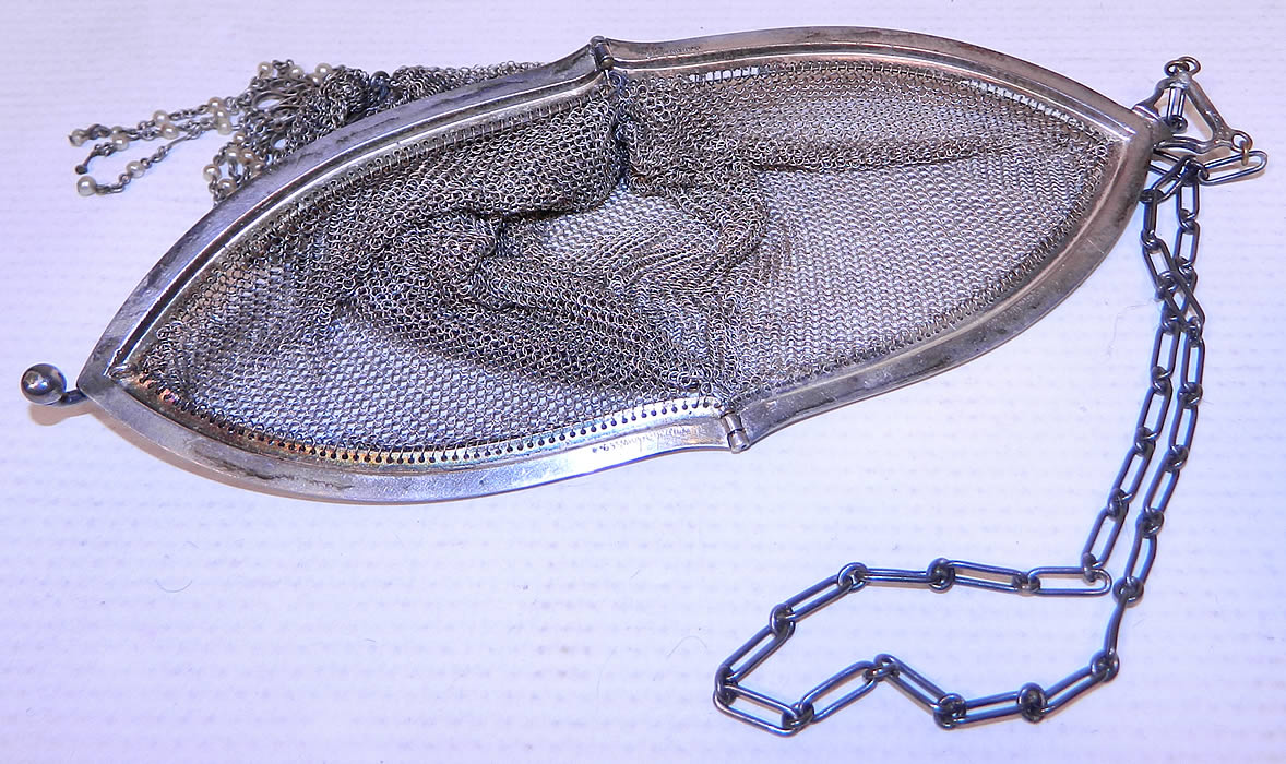 Vintage Whiting & Davis Co Silver Mesh Chainmail Flapper Purse
This fabulous flapper handbag purse has a long oval shape, with silver plated frame stamped inside "Whiting & Davis Co.", a ball clasp closure on top, chainlink carrying strap and is sheer, unlined. The purse measures 7 inches long and 3 inches wide. 