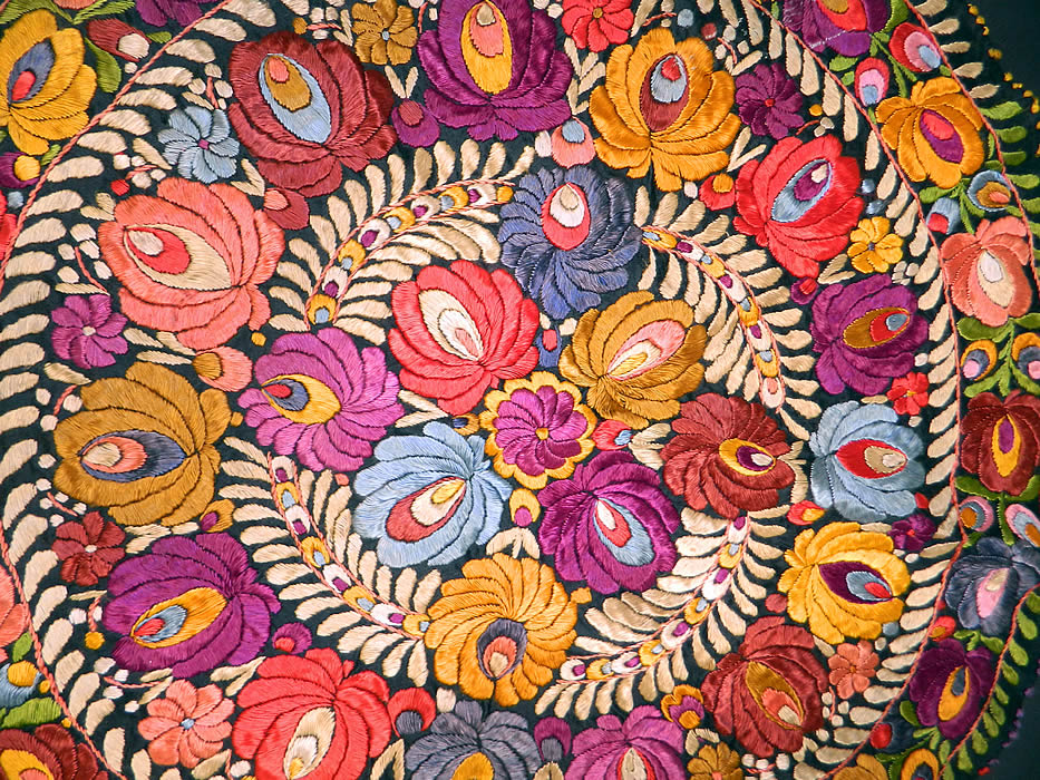 Vintage Matyo Hungarian Folk Embroidery Colorful Floral Round Tablecloth
There is a floral pattern design densely embroidered onto the fabric, with a green & cream leaf embroidered edging trim border. 

